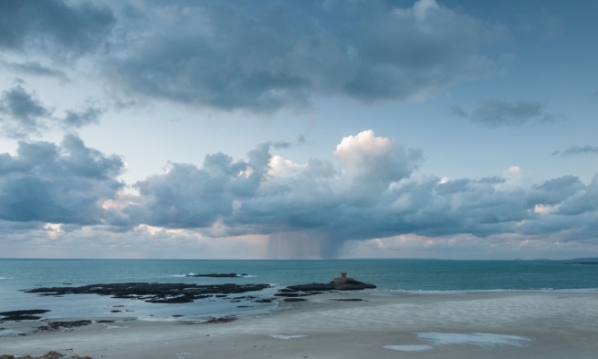 Beach, sea, clouds and La Rocco Tower from La Carriere headland, St. Brelade, Jersey, Channel Islands