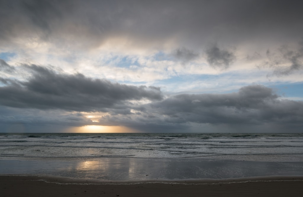 Seascape showing sunset and clouds and waves on the beach at St. Ouen's Bay, St. Ouen, Jersey, Channel Islands