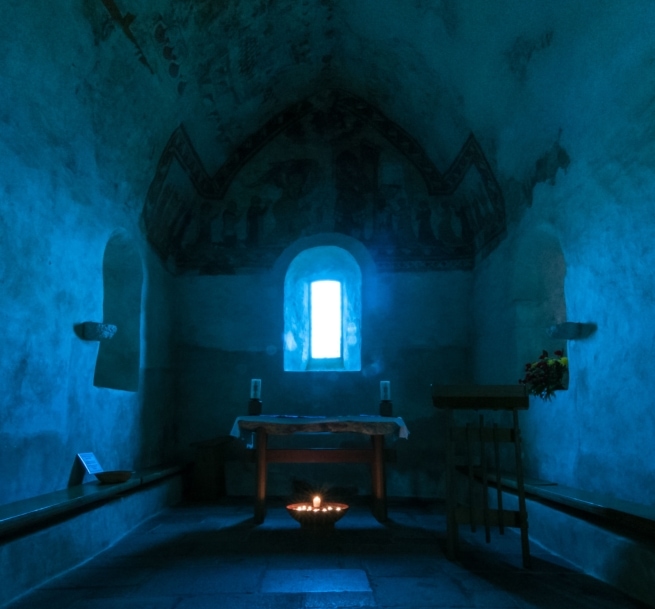 Candles and wall paintings in the old Fisherman's Chapel, St. Brelade's Church, St. Brelades Bay, St. Brelade, Jersey, Channel Islands