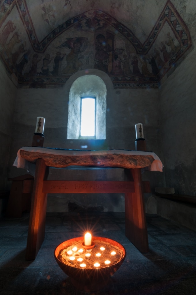 Candles and wall paintings in the old Fisherman's Chapel, St. Brelade's Church, St. Brelades Bay, St. Brelade, Jersey, Channel Islands