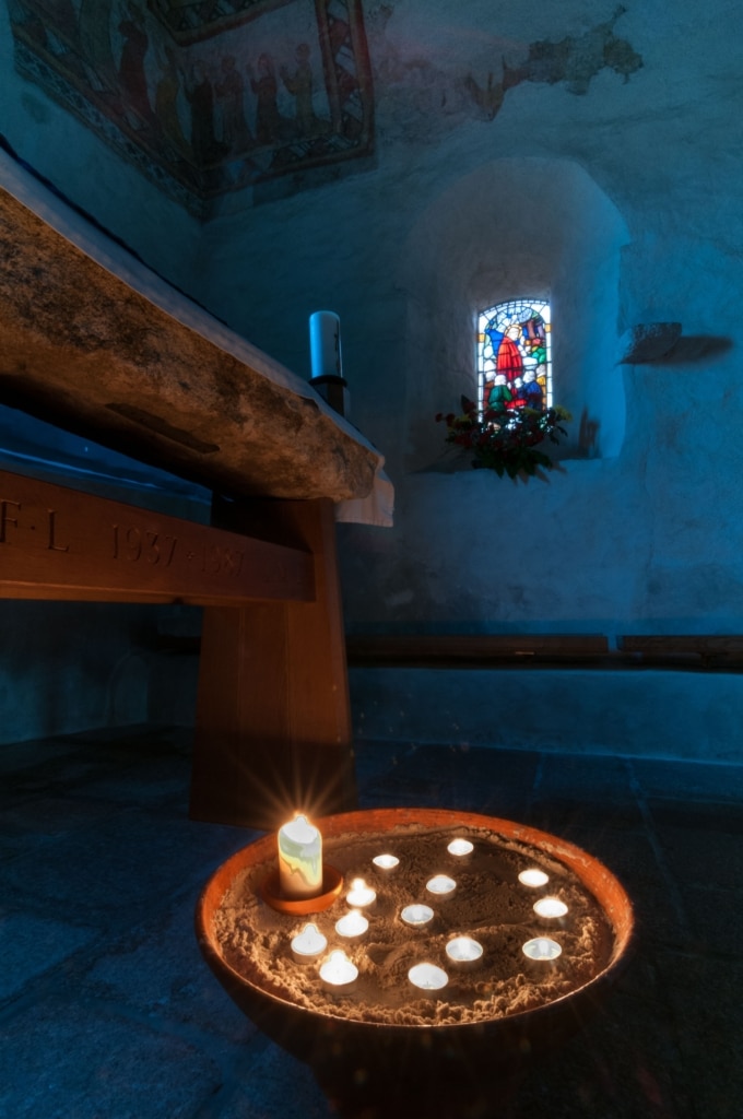 Candles and wall paintings in the old Fisherman's Chapel, St. Brelade's Church, St. Brelades Bay, St. Brelade, Jersey, Channel Islands