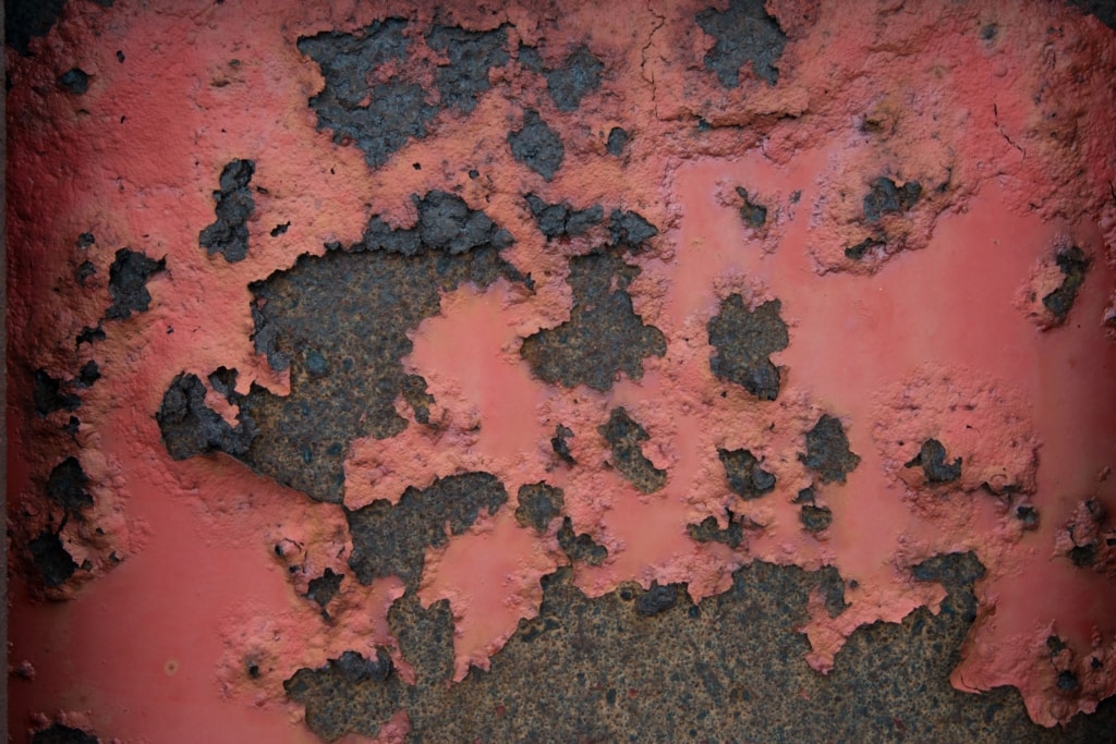 Close up showing coloured and textured rust on agricultural machinery near La Saline Slip, St. Ouen, Jersey, Channel Islands