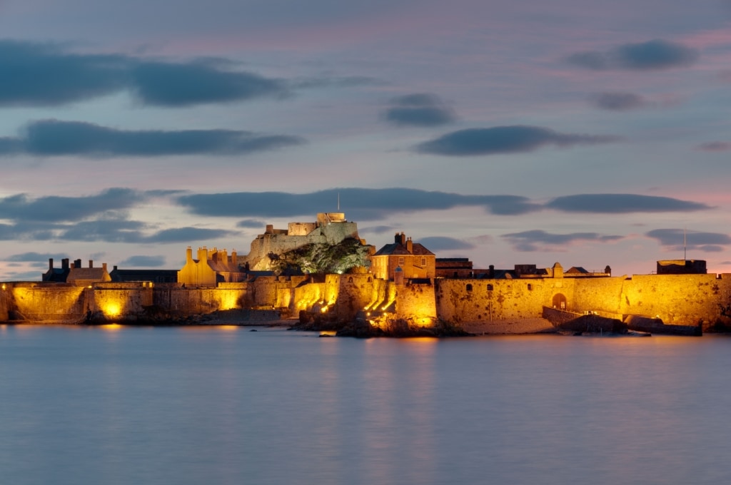 Illuminated Elizabeth Castle at sunset, St. Helier Marina, St. Helier, Jersey, Channel Islands