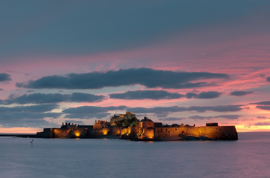 Illuminated Elizabeth Castle at sunset, St. Helier Marina, St. Helier, Jersey, Channel Islands