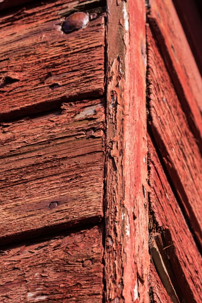 Flaking paint on old red fishing hut at Bonne Nuit Bay, St. John, Jersey, Channel Islands