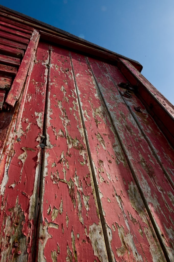 Flaking paint on old red fishing hut on Rozel Pier, Rozel Bay, St. Martin, Jersey, Channel Islands