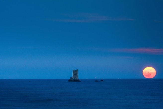 Full moon rising next to Seymour Tower, La Rocque, Grouville, Jersey, Channel Islands