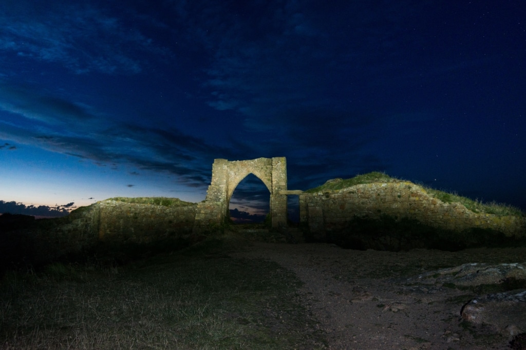 Grosnez Castle ruins after sunset by torch, St. Ouen, Jersey, Channel Islands