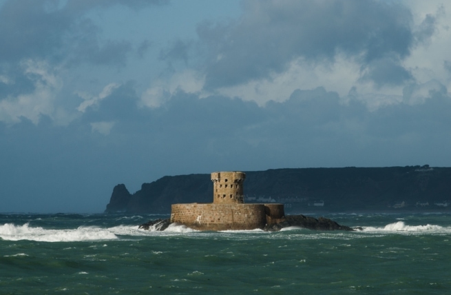 Wild and windy seascape after heavy rain showing La Rocco Tower and St. Ouen's Bay from La Pulente Slip, St. Brelade, Jersey, Channel Islands