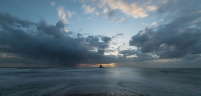 Long exposure seascape showing the clouds and tide and La Rocco Tower at sunset, taken from Le Braye Slipway, St. Brelade, Jersey, Channel Islands