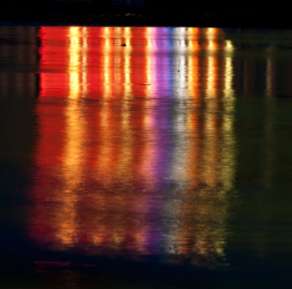 Lights on Gorey Pier reflected in the wet sand, Gorey, St. Martin, Jersey, Channel Islands