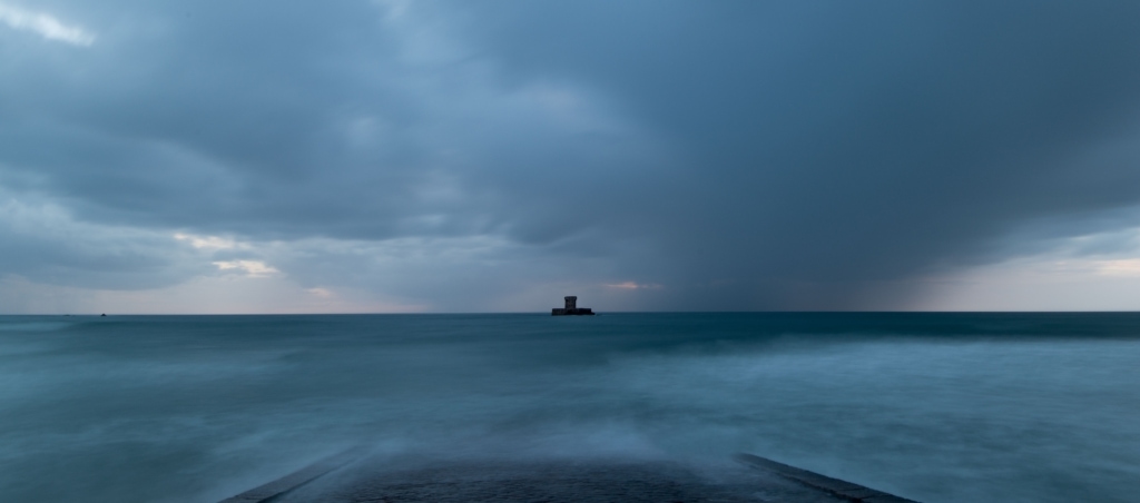 Long exposure seascape showing the clouds and tide and La Rocco Tower after sunset, taken from Le Braye Slipway, St. Brelade, Jersey, Channel Islands