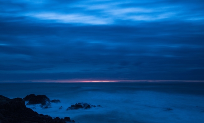 Long exposure showing the last remnants of light over the wispy sea at Le Grouet, St. Brelade, Jersey, Channel Islands