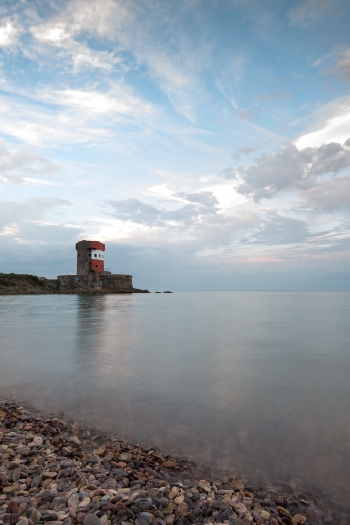 Red and white Martello Tower and tranquil sea from the beach at Archirondel, St. Martin, Jersey, Channel Islands