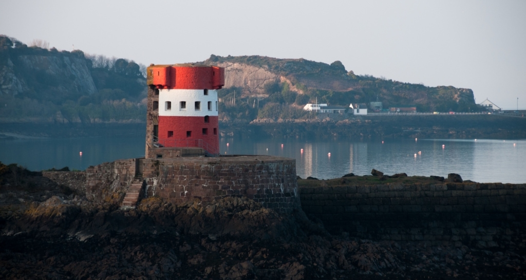 Red and white Martello Tower at Archirondel, St. Martin, with St. Catherine's behind, Jersey, Channel Islands