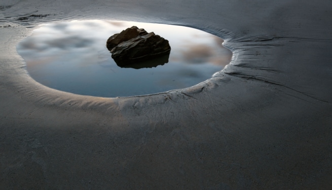 Rock pool on the beach at sunset, taken in front of Faulkner Fisheries at L'Etacq, St. Ouen, Jersey, Channel Islands