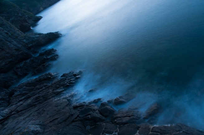 Sea and rocks after sunset from Greve De Lecq Pier looking towards Plemont headland, St. Ouen, Jersey, Channel Islands