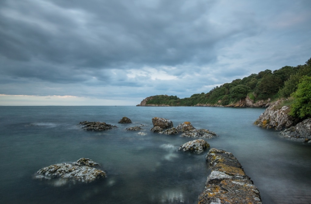 Seascape featuring rocks and clouds at high tide at La Saie Harbour, St. Martin, Jersey, Channel Islands