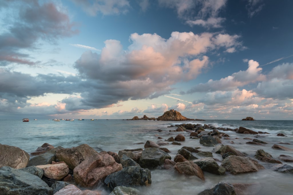 Seascape showing rocks and clouds at sunset at high tide at Le Hocq Slipway, St. Clement, Jersey, Channel Islands