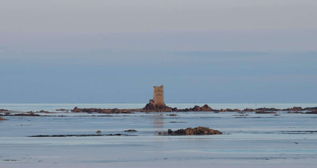 Seascape showing Seymour Tower and surrounding rocks as the tide rises, taken with a long zoom lens from the vicinity of La Rocque, Grouville, Jersey, Channel Islands