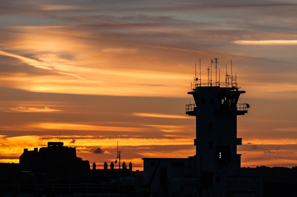 Silhouette showing the Port Control Tower and Elizabeth Castle at sunset, St. Helier Harbour, St. Helier, Jersey, Channel Islands