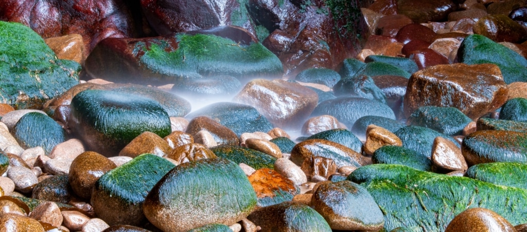 Small waterfall landing on rocks outside Plemont Caves, Plemont Bay, St. Ouen, Jersey, Channel Islands