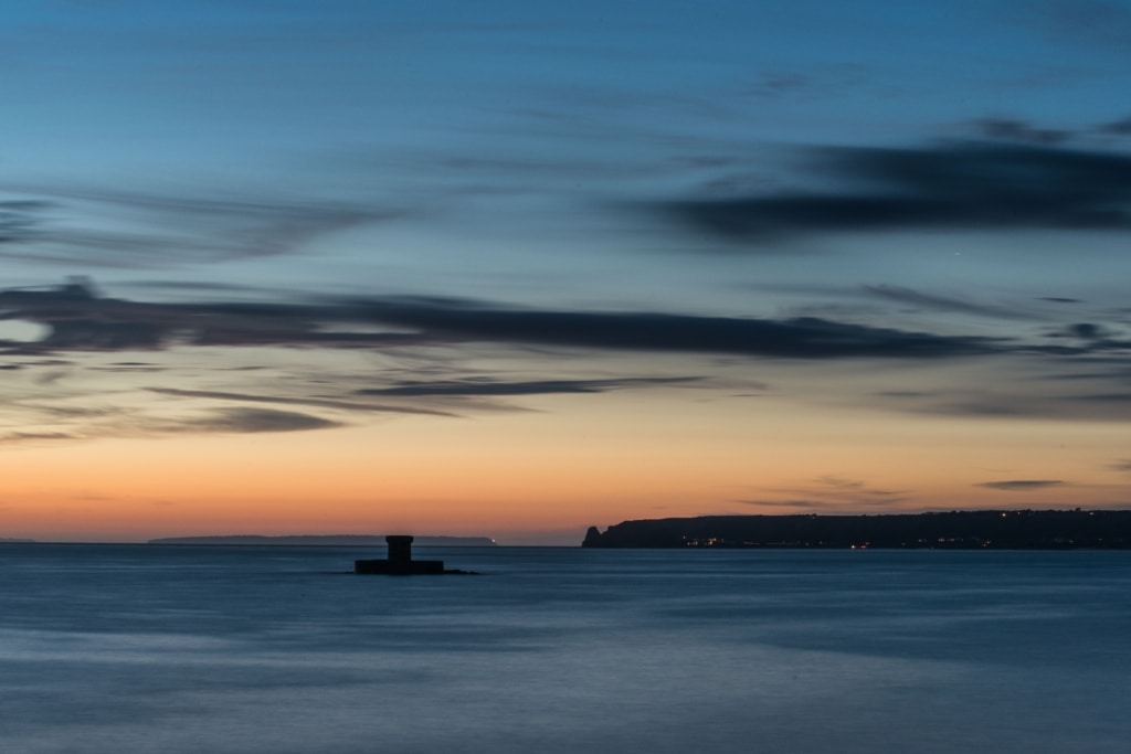 Seascape looking across St. Ouen's Bay towards La Rocco Tower and Le Pinacle and the other islands at sunset, taken from La Pulente, St. Brelade, Jersey, Channel Islands