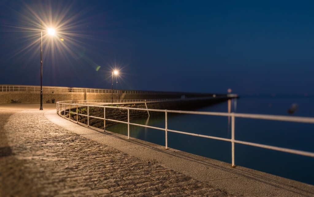 Selective focus view showing starry lights looking down St. Catherine's Breakwater at night, St. Martin, Jersey, Channel Islands