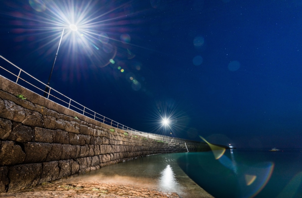 View showing starry lights looking down St. Catherine's Breakwater at night from the slipway, St. Martin, Jersey, Channel Islands