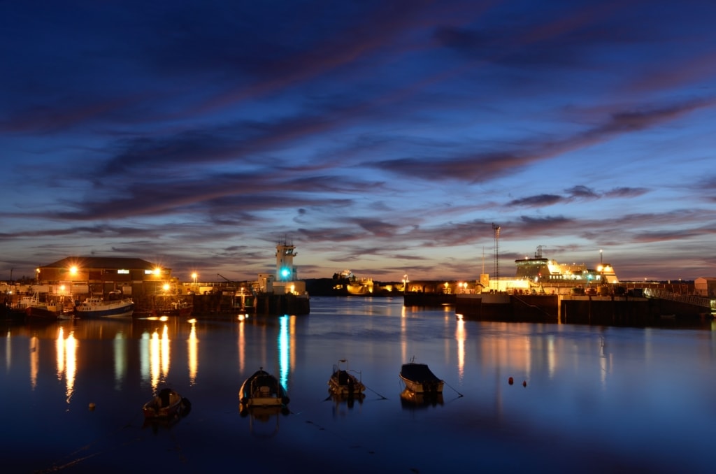 Beautiful sunset looking across St. Helier Harbour towards the Port Control Tower and Elizabeth Castle, and just after dark when the harbour lights come on, St. Helier, Jersey, Channel Islands