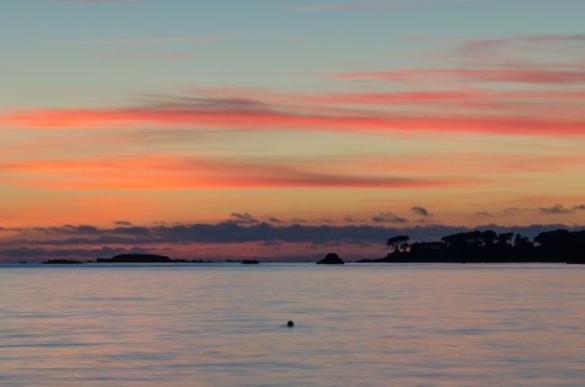 Beautiful sunset and seascape looking towards Green island with a long lens and long exposure from La Charrière au Long Slip, St. Clement, Jersey, Channel Islands