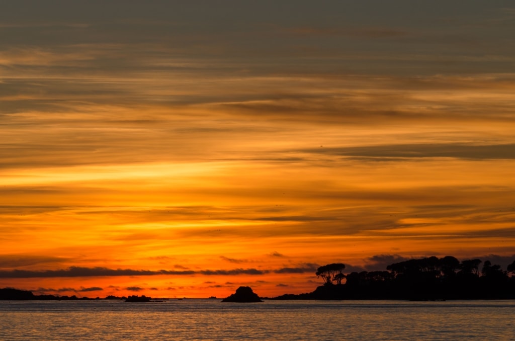 Beautiful sunset and seascape looking towards Green Island with a long lens and long exposure from La Charriere au Long Slip, St. Clement, Jersey, Channel Islands