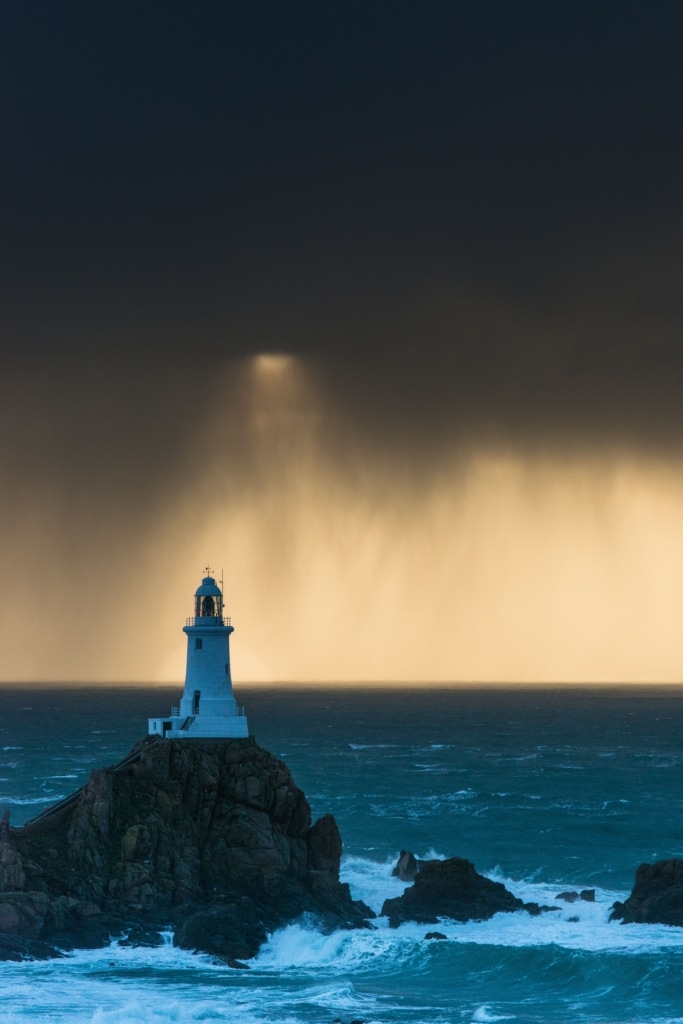 Seascape showing sunset at Corbiere Lighthouse during a really heavy rain storm, Corbiere, St. Brelade, Jersey, Channel Islands