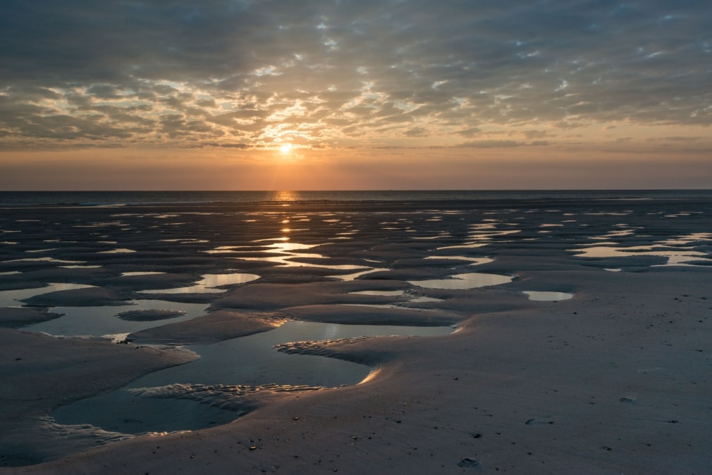 Sunset on the beach with interesting clouds and interesting puddles, near L'Ouziere Slip, St. Ouen's Bay, St. Ouen, Jersey, Channel Islands