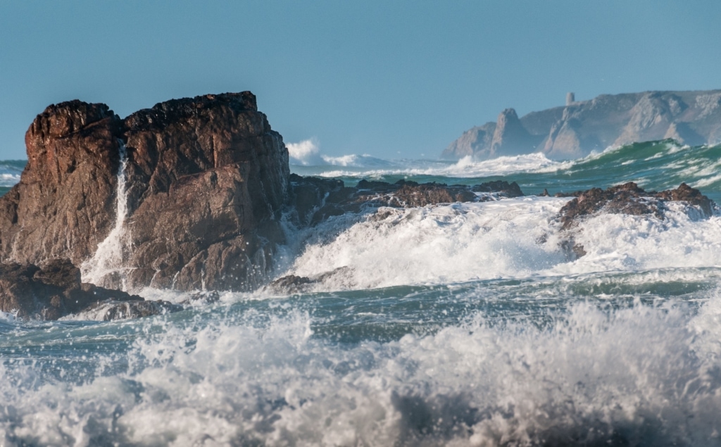 Surf and rocks looking across St. Ouen’s Bay from Corbiere Lighthouse Causeway, St. Brelade, Jersey, Channel Island