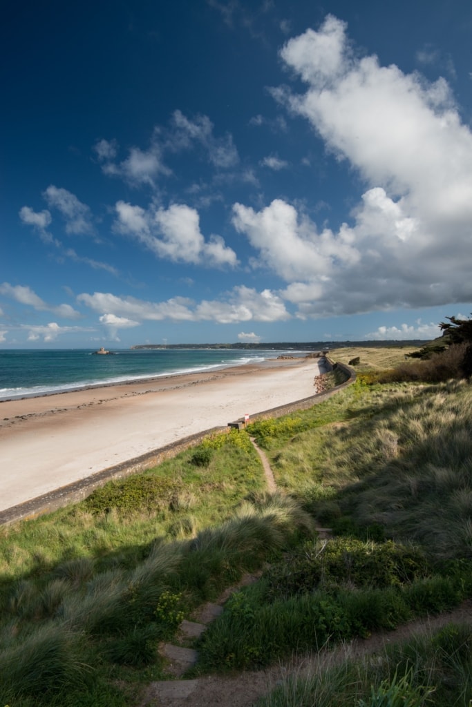 Mid morning shot of the beach at La Pulente with blue sky and fluffy clouds behind, St. Brelade, Jersey, Channel Islands