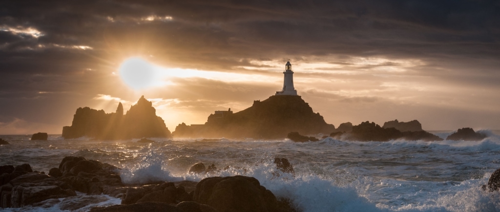 Waves and surf and sunset at Corbiere Lighthouse, St. Brelade, Jersey, Channel Islands