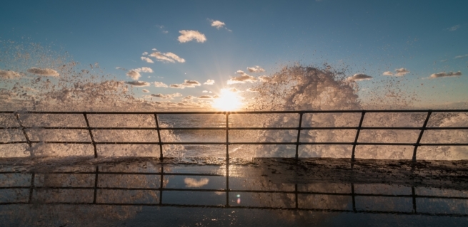 Waves bouncing off the sea wall at sunset, St. Ouen's Bay, St. Peter, Jersey, Channel Islands