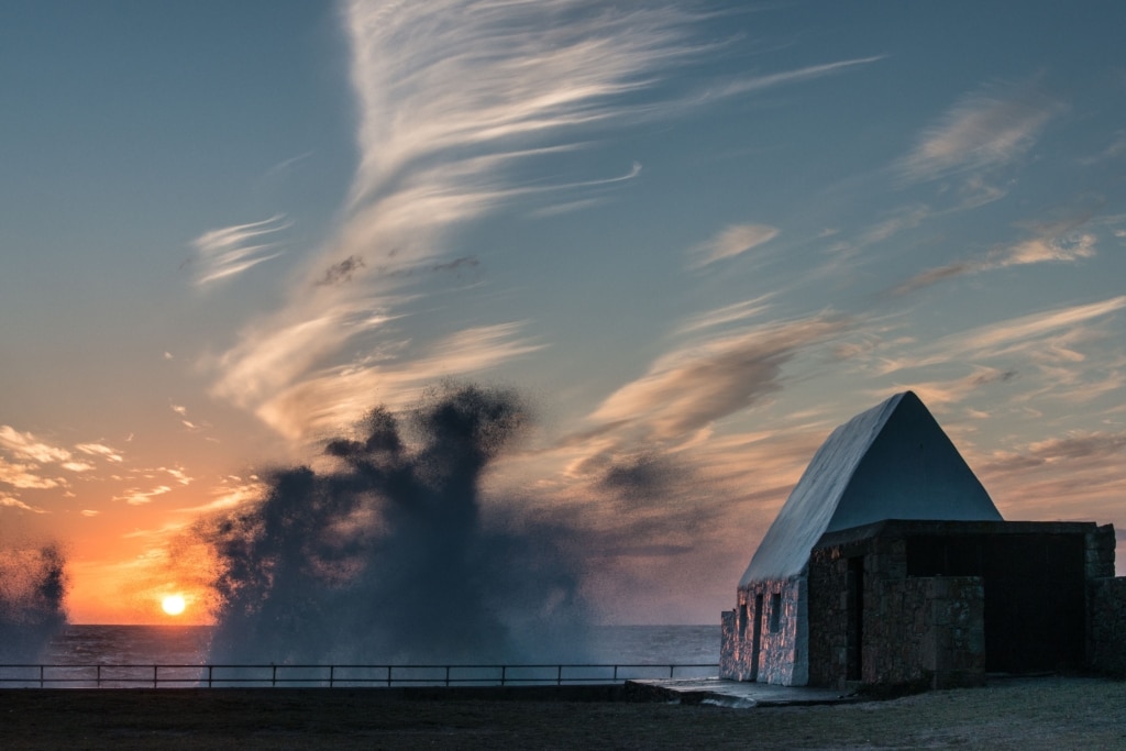 Waves splashing off the sea wall at sunset at The White House, St. Peter, Jersey, Channel Islands